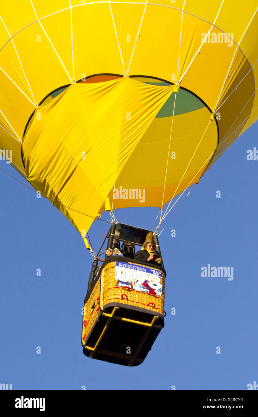 Close-up of a hot air balloon, taking off from the ground with a couple people in the gondola - Smartphone Captured Stock Image