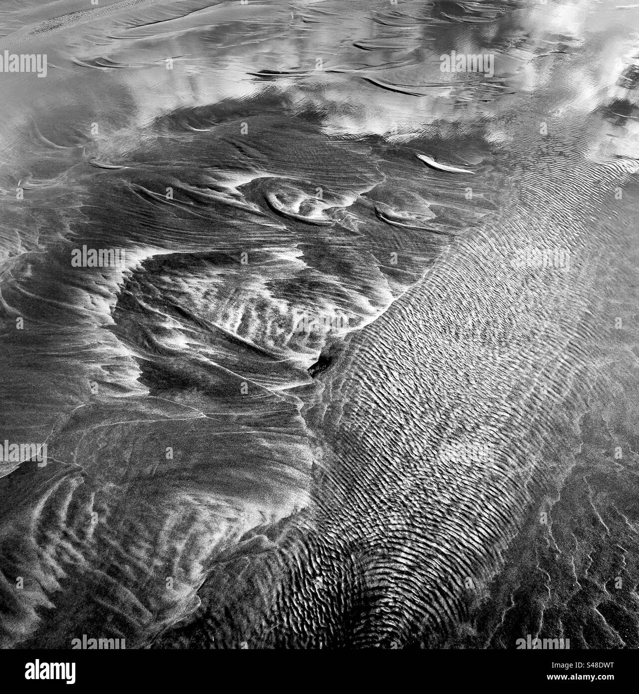Patterns in the sculpted sand caused by tidal action at the beach - Smartphone Captured Stock Image