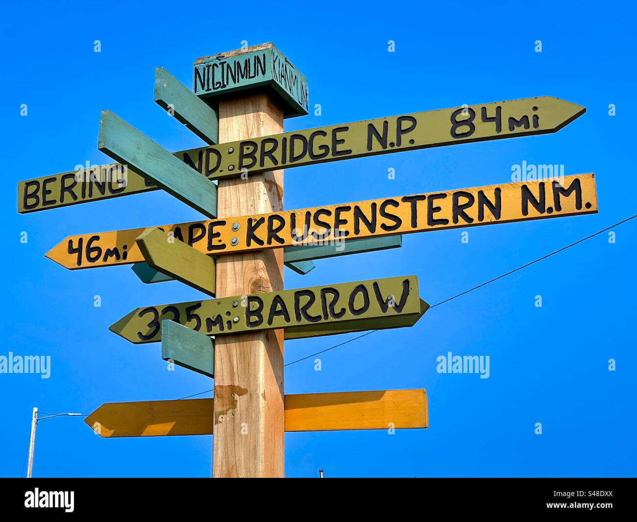 Tourist sign post directing toward regional Arctic destinations in the Alaskan Arctic town of Kotzebue Stock Photo