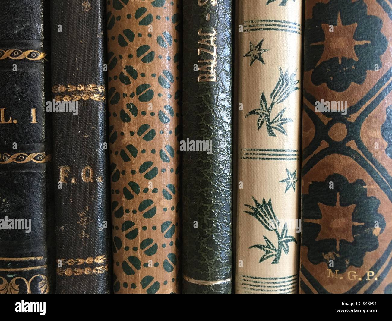 Closeup of the covers of some old books. Bound books with golden