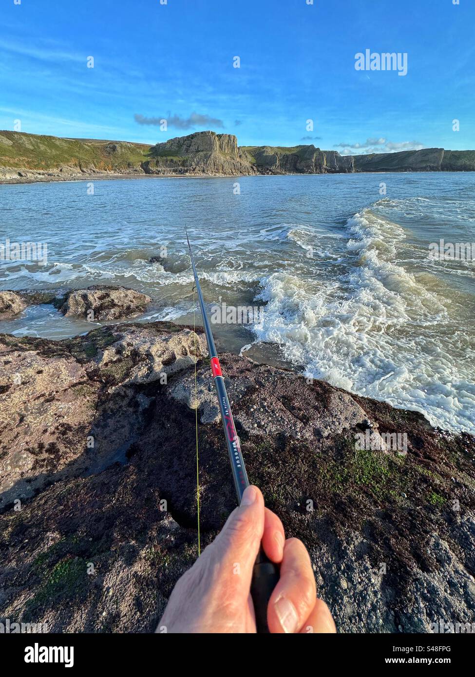 Fishing at Fall Bay, looking towards Mewslade Bay, Gower peninsula, Wales. - Smartphone Captured Stock Image