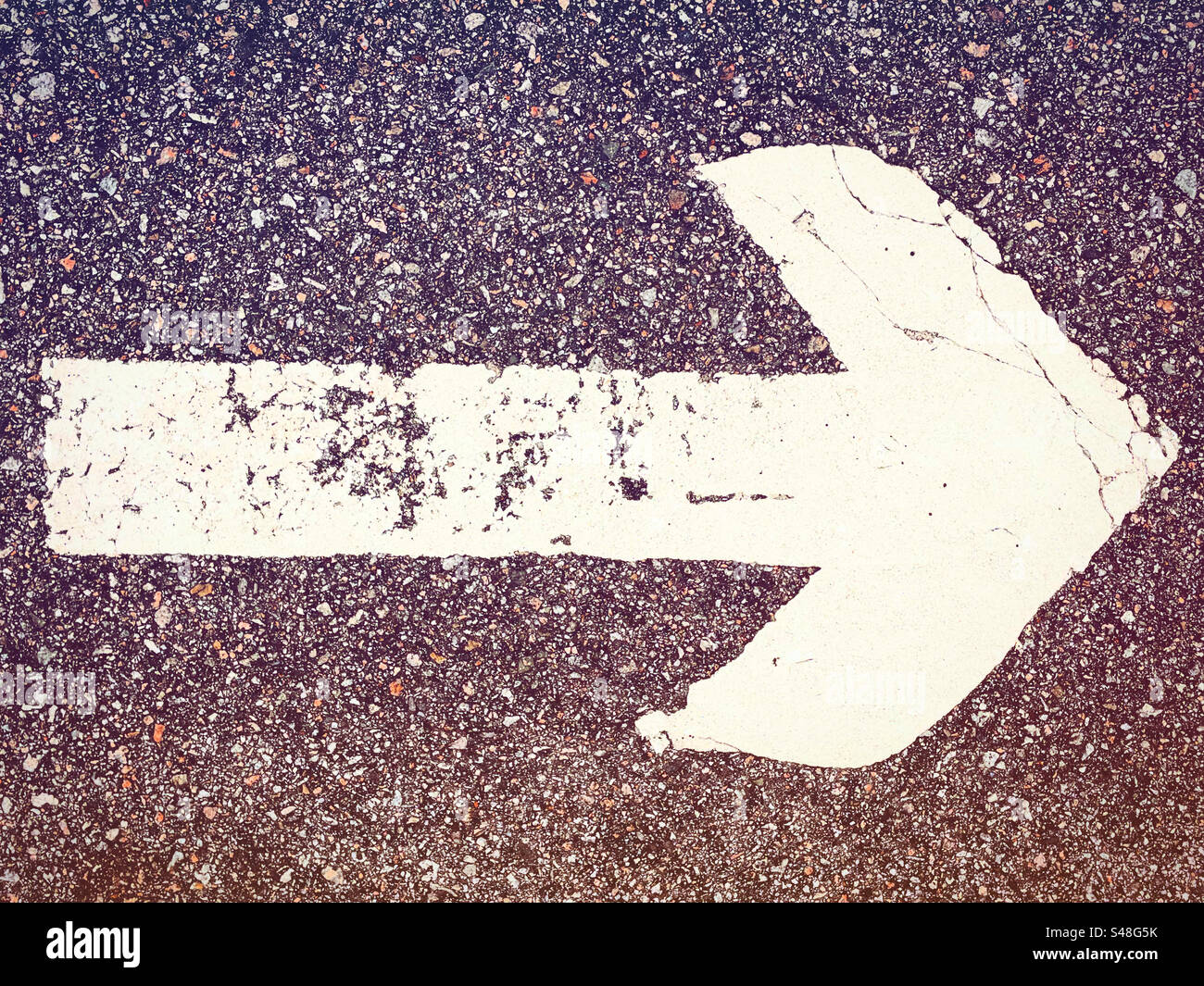 white rough textured arrow pointing right direction on a sidewalk or pavement floor for the pedestrans or drivers to follow for safety after indications in the city urban town - Smartphone Captured Stock Image