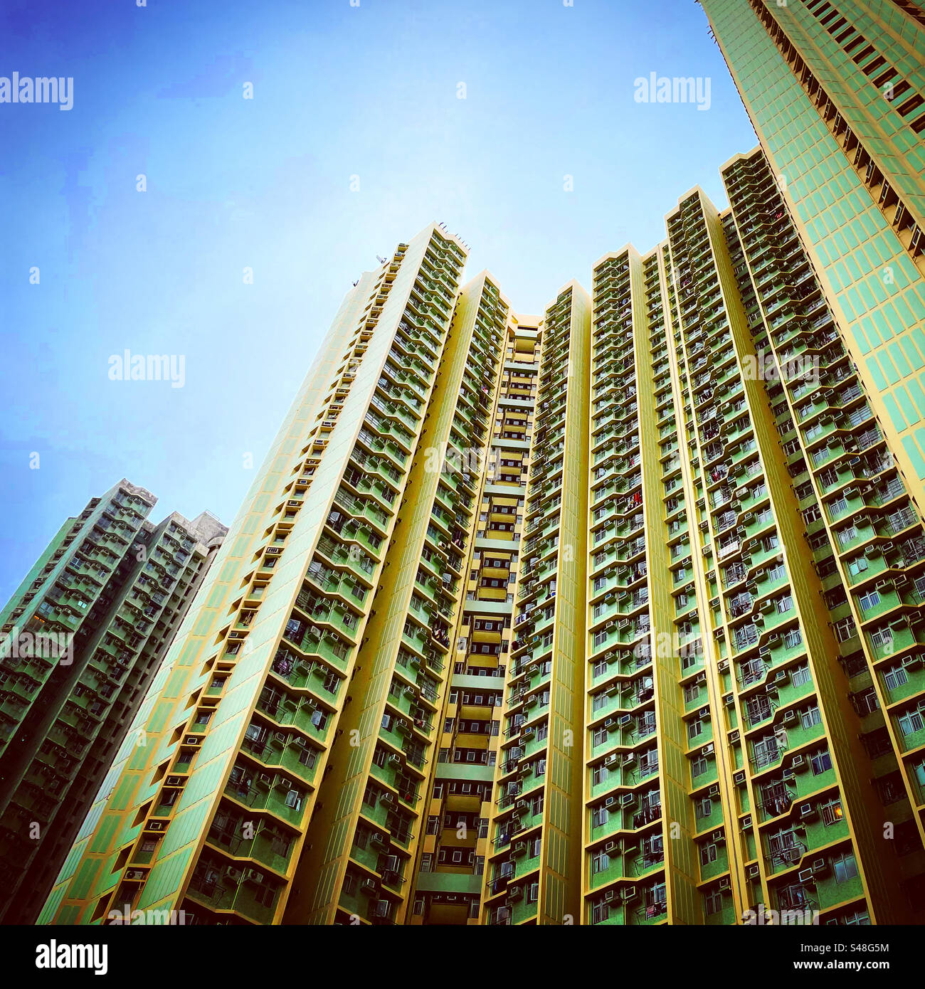 Perpective of hong kong complex skyscraper council flat towers in yellow color with same architecture - Smartphone Captured Stock Image