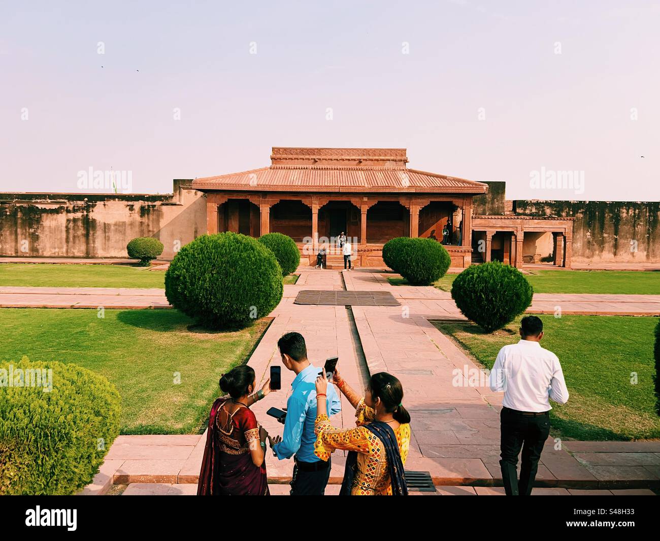 Indian tourists dressed in bright coloured traditional clothes clicking selfies at UNESCO World Heritage Site in Fatehpur Sikri in India Stock Photo