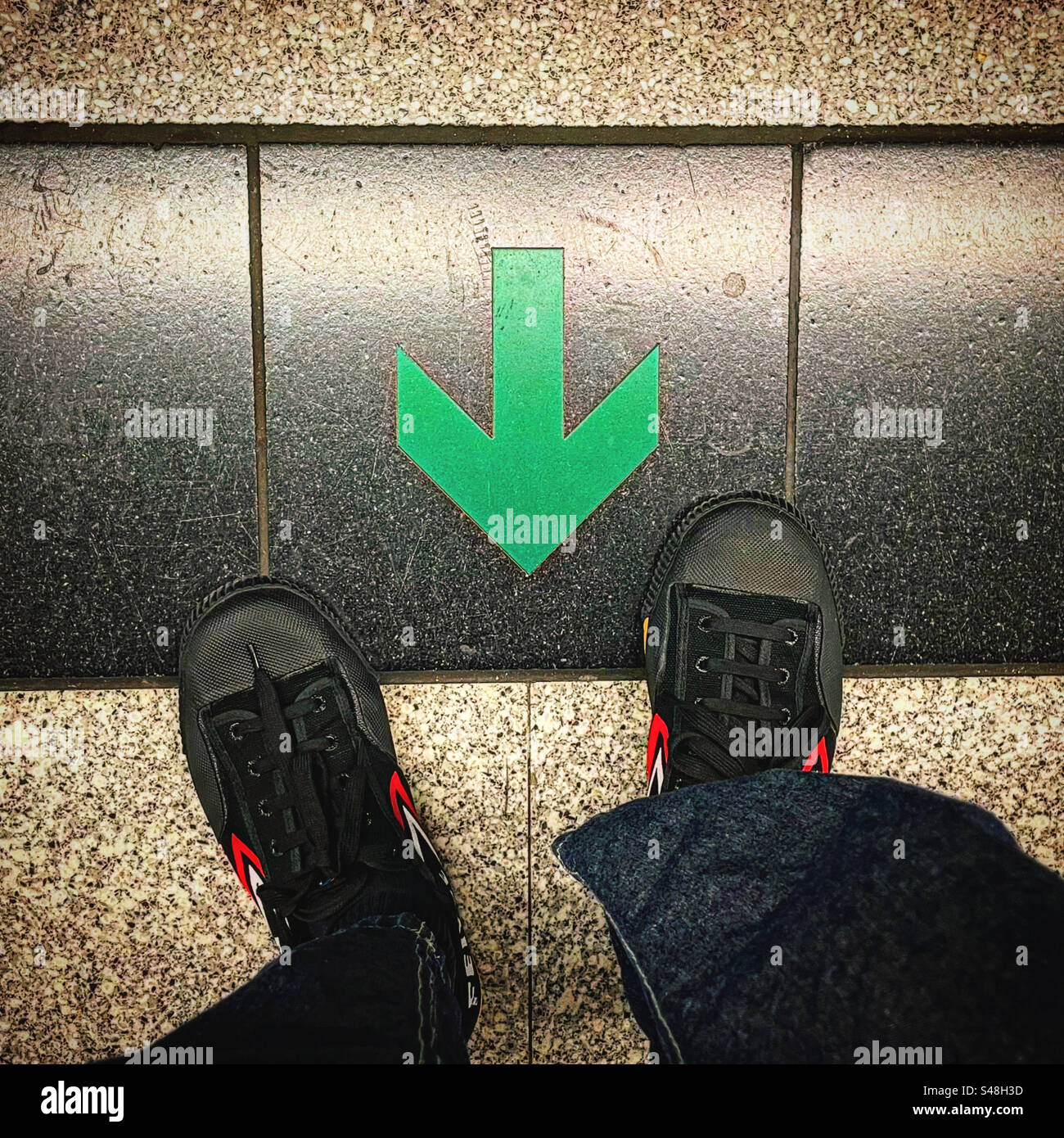 green arrow saying where to stand. It is a green arrow pointing down - Smartphone Captured Stock Image