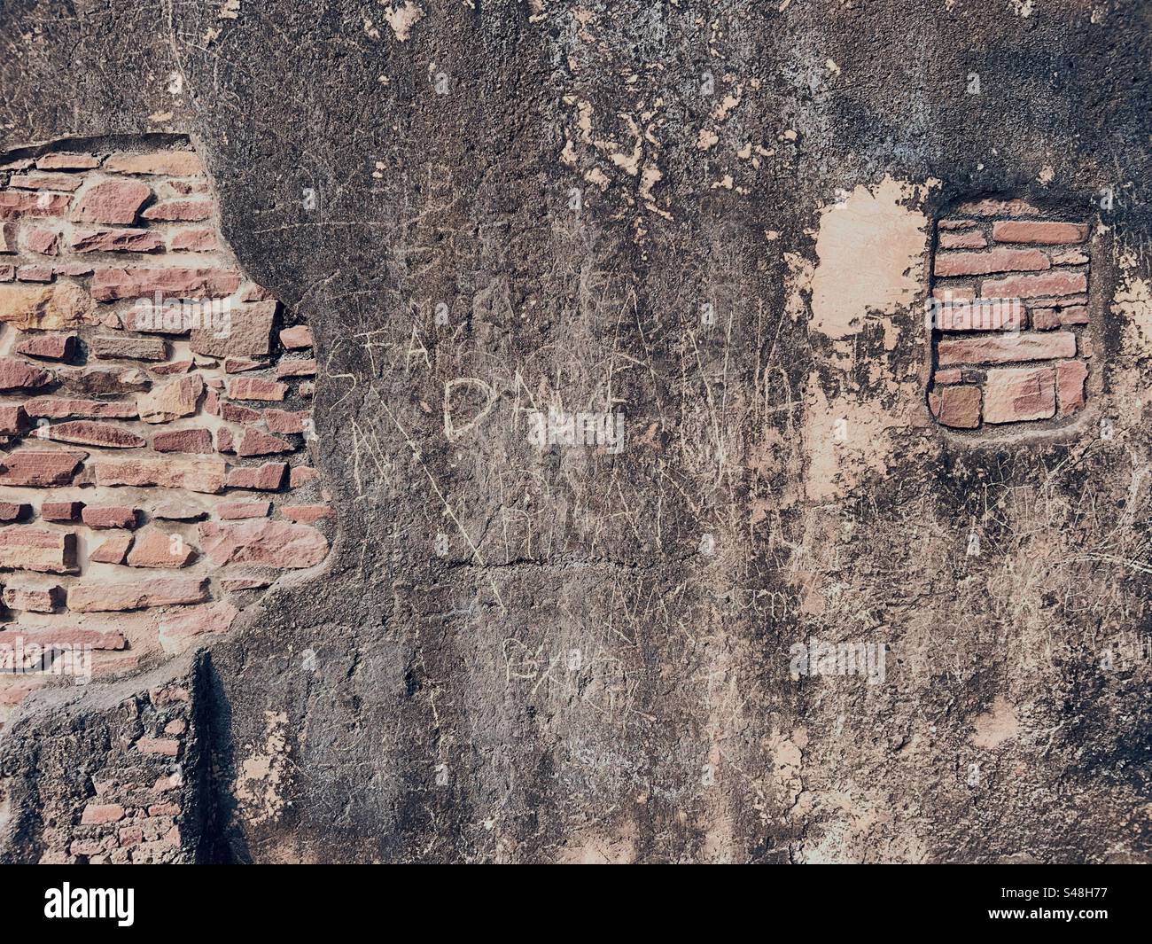 Texture and graffiti on the walls of the palace at Fatehpur in India - Smartphone Captured Stock Image