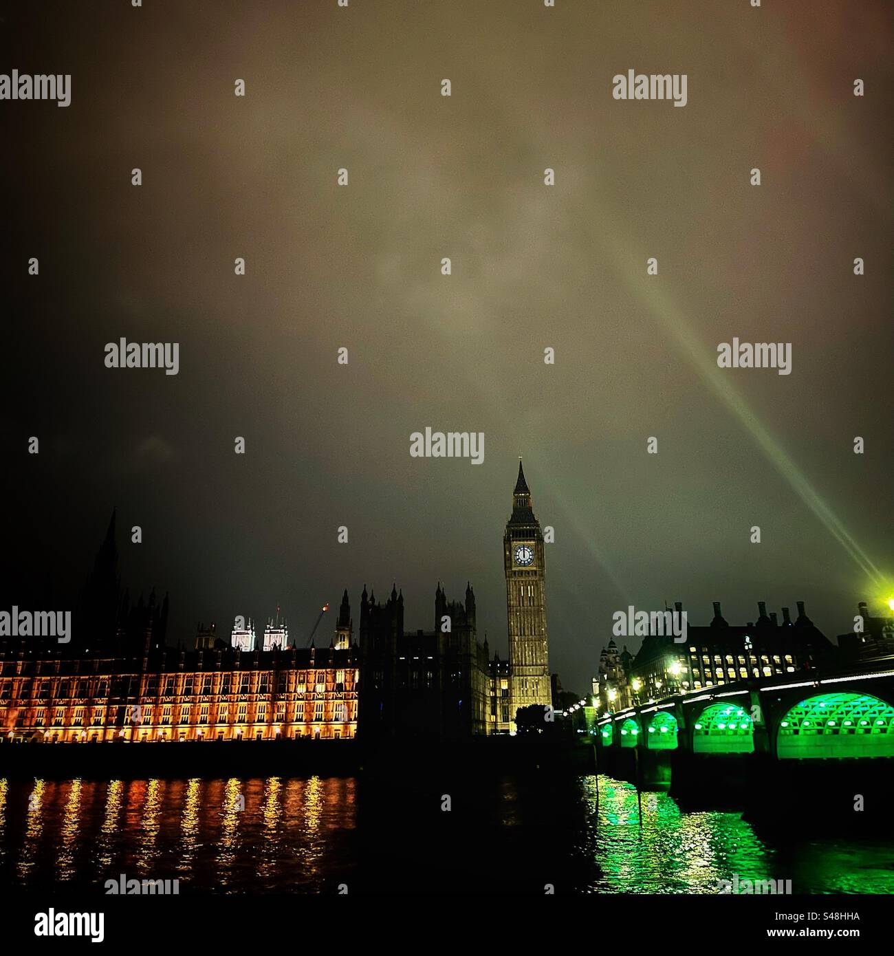 Westminster Bridge and the Houses of Parliament at night - the clock strikes midnight with Westminster Abbey in the distance - Smartphone Captured Stock Image