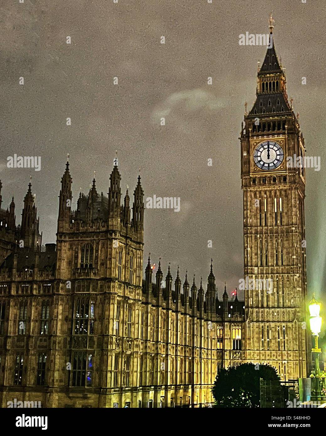 Midnight on the clock face of Big Ben - House of Commons at night. Gothic architecture seen from Westminster Bridge, SW1 Stock Photo