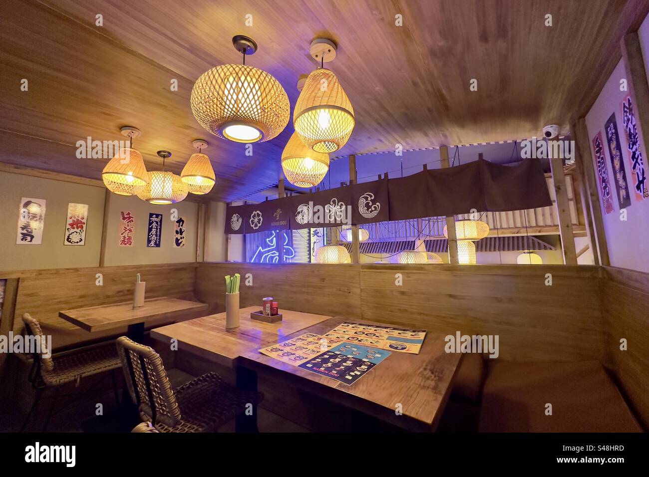 Japanese Chinese Vietnamese restaurant interior with tables, ceiling lights, menus and chairs. Stock Photo