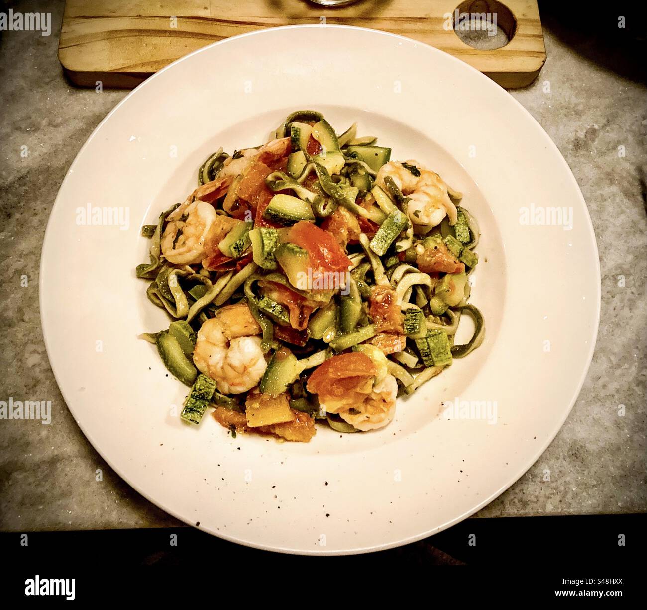 Fresh spinach pasta with shrimp tomato and garlic. Amazing meal. - Smartphone Captured Stock Image