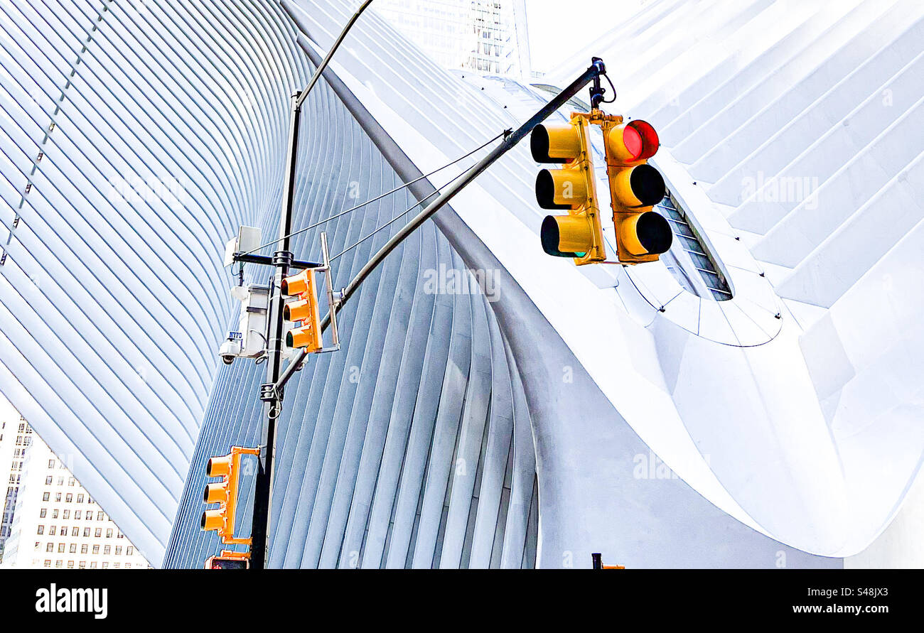 Traffic lights on red in front of modern architecture of the Oculus building (part of World Trade Center) in Manhattan, New York - Smartphone Captured Stock Image