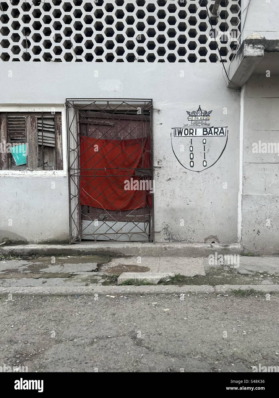 Façade in Cuba near Belascoaín street with text in the outside wall reading ‘Orula, San Lazaro y Yemaya, Iwori Bara’ Stock Photo