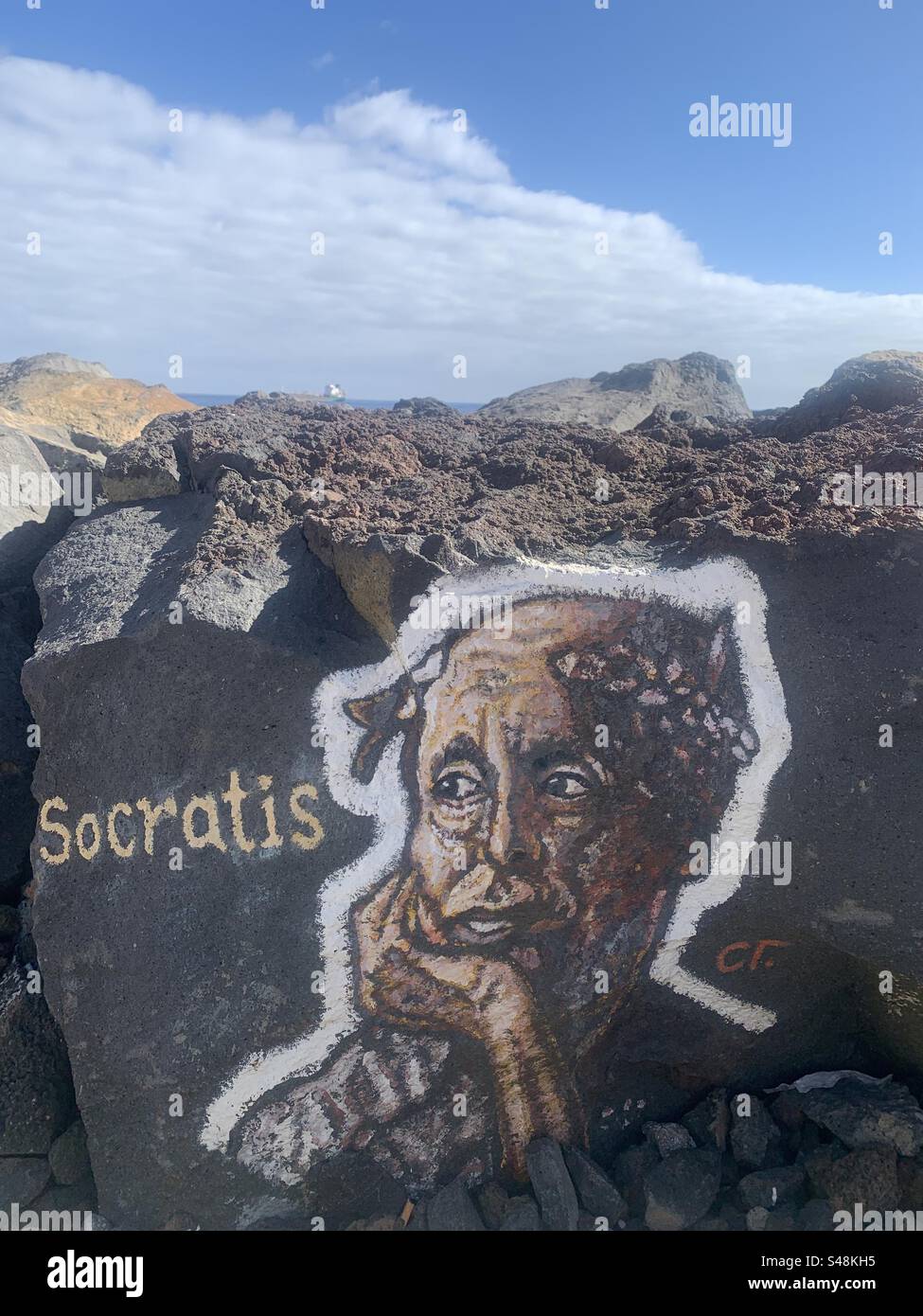 Painting of Socrates on a rock in Tenerife with cloud and sky in the background - Smartphone Captured Stock Image