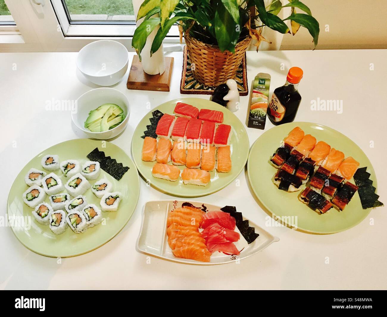 A collection of homemade sushi platters on a kitchen counter table - Smartphone Captured Stock Image