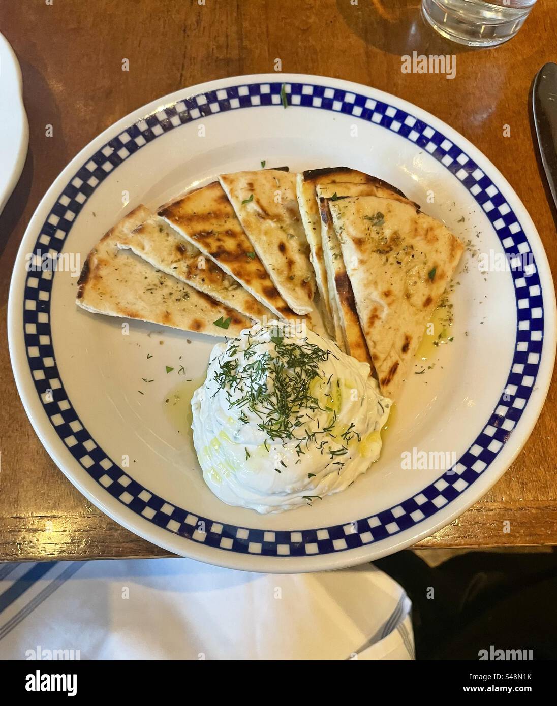 a plate of tzatziki with triangles of pita bread - Smartphone Captured Stock Image