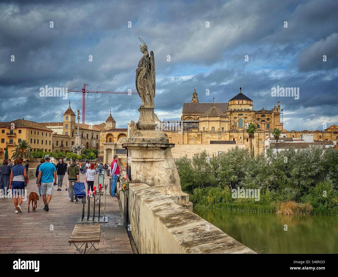 People walking on old Roman Bridge near an angel statue with views at the historical center of Córdoba in Spain. - Smartphone Captured Stock Image