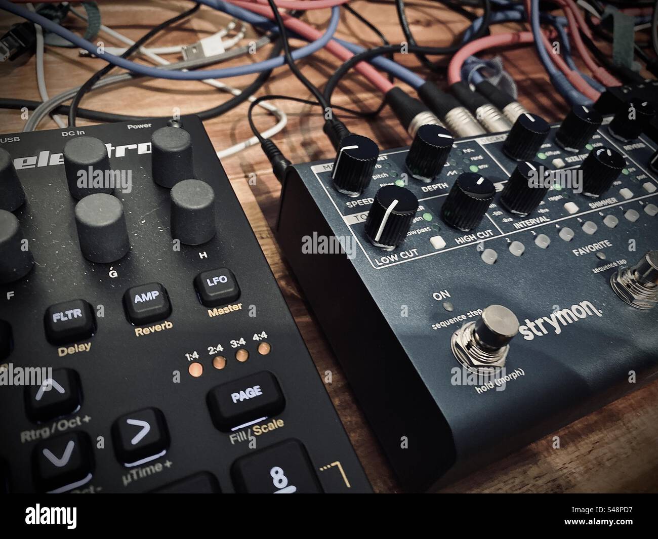 Elektron Digitakt sampler and Strymon NightSky effects pedal with messy nest of cables. Electronic music production. - Smartphone Captured Stock Image