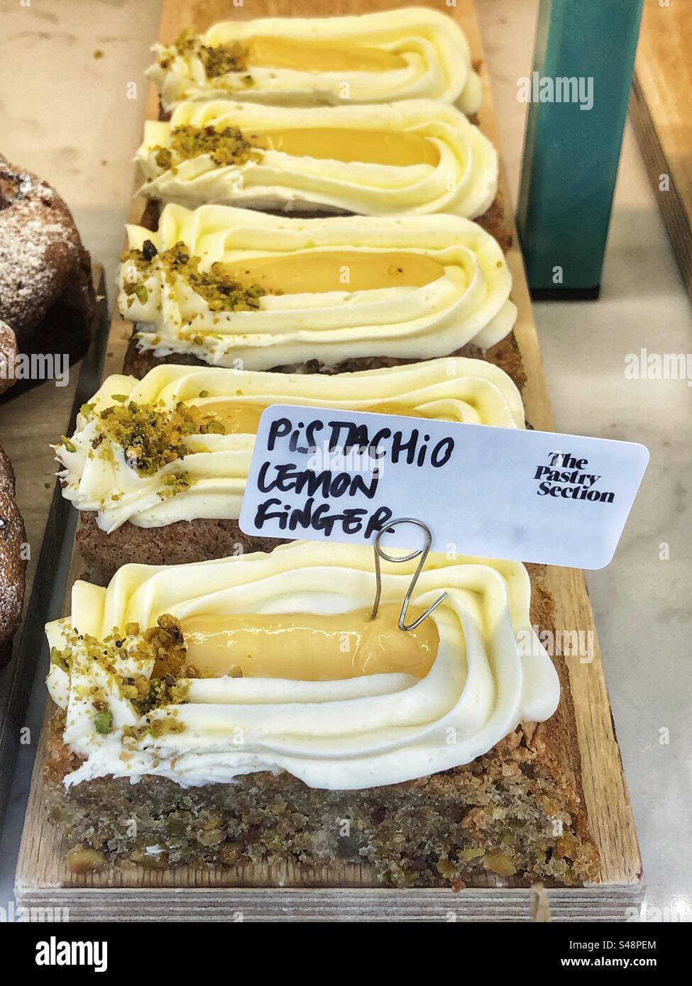 Pistachio Lemon Finger cake in bakery shop window - Smartphone Captured Stock Image