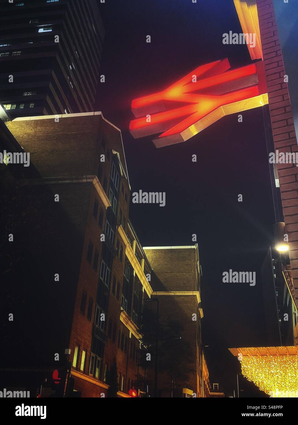 Close up red illuminated National Rail sign outside London Bridge station at night. - Smartphone Captured Stock Image
