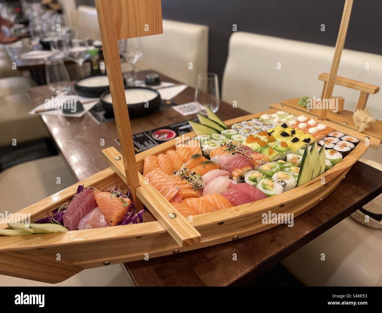 Shot of a boat shaped wooden sushi platter in a Japanese restaurant in Martigues, Côtes du Rhône, France - Smartphone Captured Stock Image