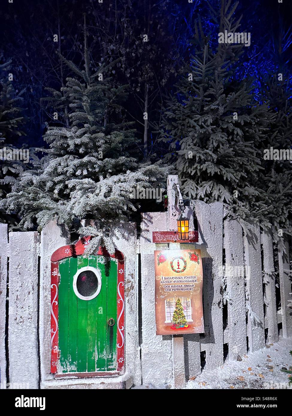 A miniature door set in a fake snow covered fence at Liseberg theme park, Gothenburg, Sweden. - Smartphone Captured Stock Image