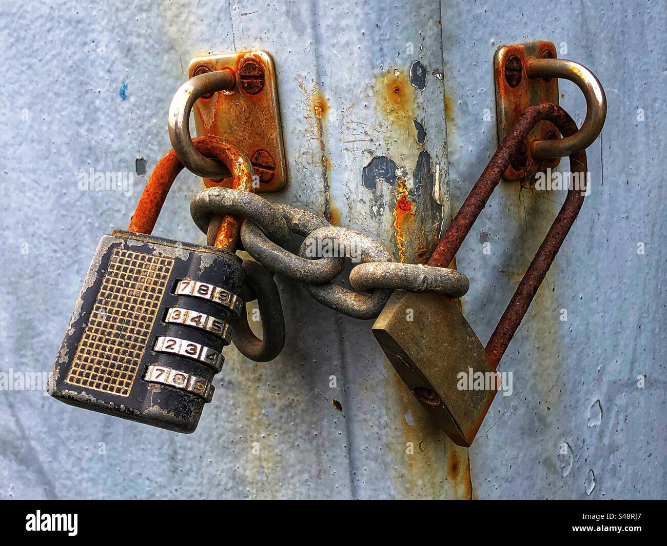 Rusting padlocks exposed to the elements outdoors - Smartphone Captured Stock Image