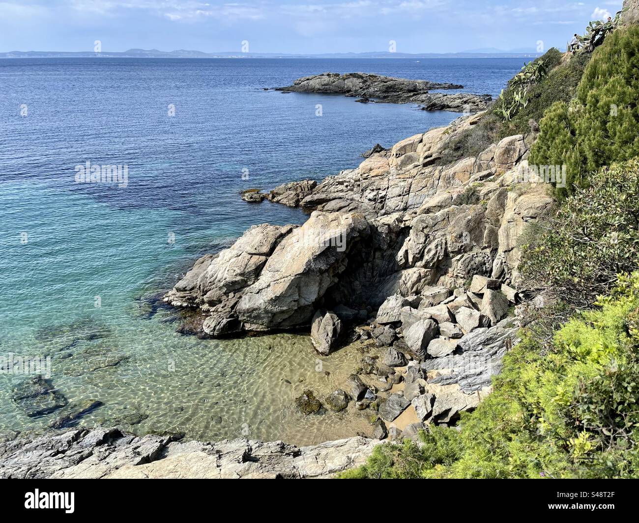 Beautiful landscape shot of Rocky beach and cliff overlooking islands on the Mediterranean in Roses, Costa Brava, Spain - Smartphone Captured Stock Image