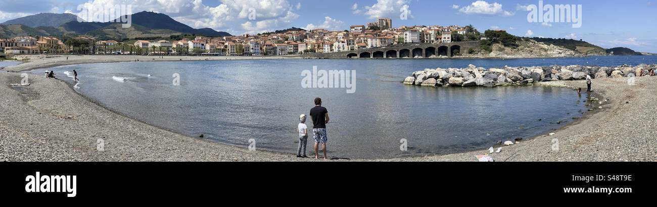 Wide panorama of father and son fishing on the beach in Cerbère, Catalogne, France near the Spanish border and Costa Brava - Smartphone Captured Stock Image