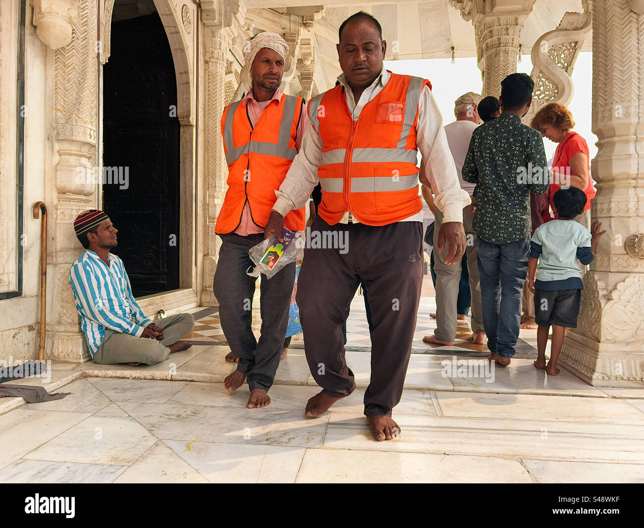Construction workers administrating repairs among tourists at the UNESCO world heritage site at Fatehpur Sikri in Uttar Pradesh in India - Smartphone Captured Stock Image