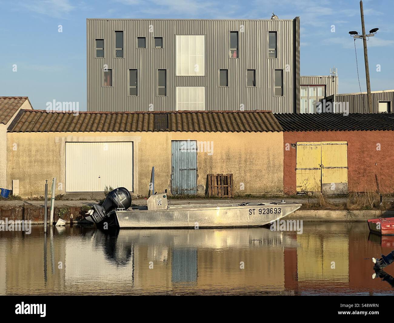 Peaceful landscape photo of an aluminum boat anchored in front of a fisherman house in Palavas-les-Flots, Occitanie, Montpellier. - Smartphone Captured Stock Image