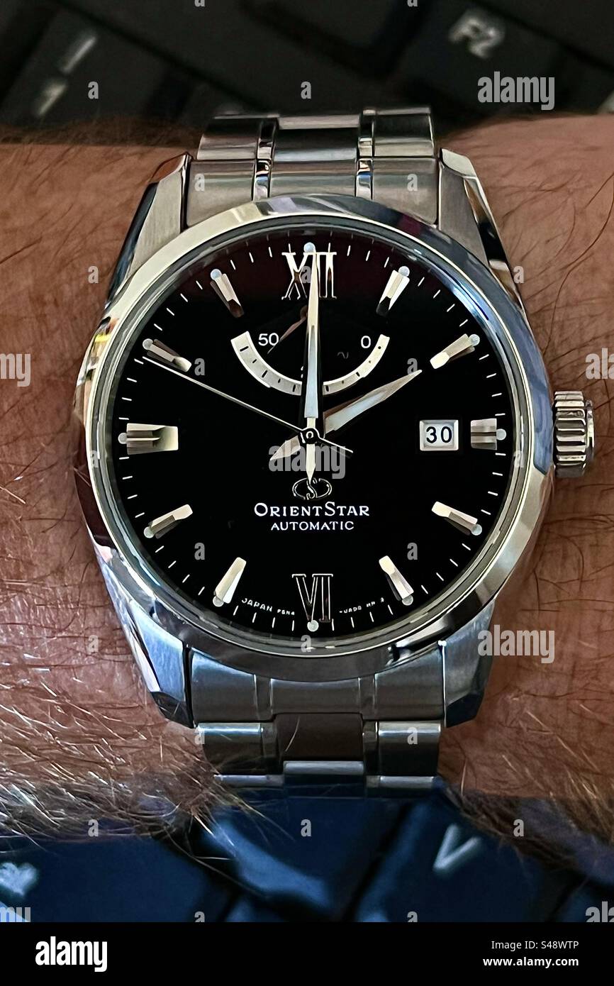 OrientStar a stainless steel automatic mechanical watch with black dial. - Smartphone Captured Stock Image