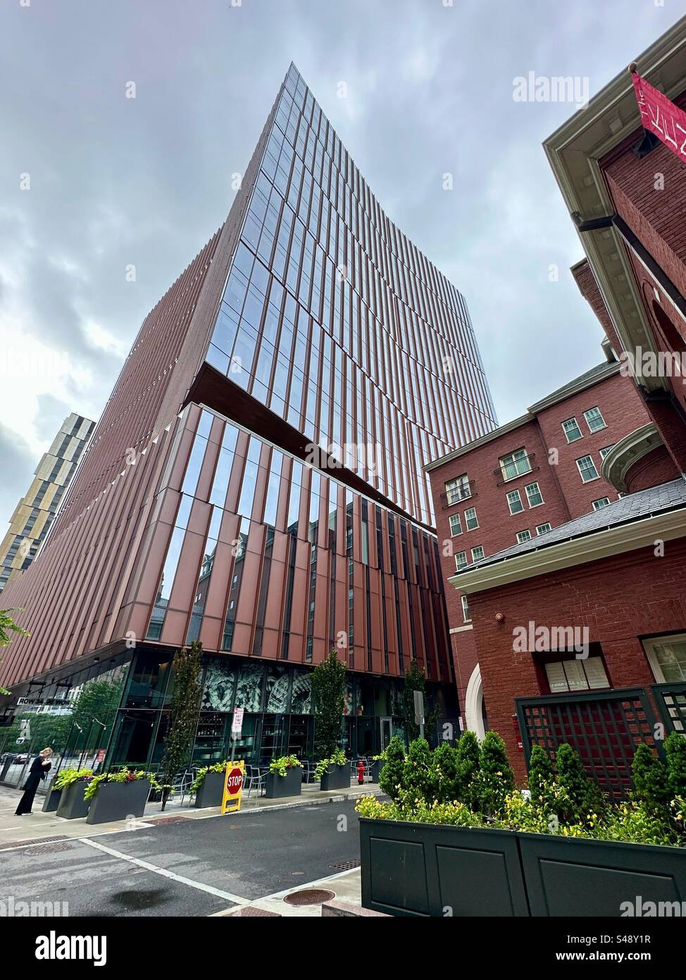 Cambridge, Massachusetts, USA:  Kendall Square cityscape. Modern office building with vintage red brick building right next to it. Cloudy, rainy day. - Smartphone Captured Stock Image