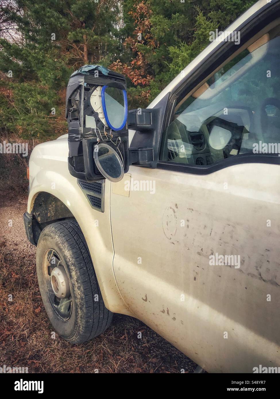 Redneck solutions- worker affixes two hand mirrors where side mirror was broken - Smartphone Captured Stock Image