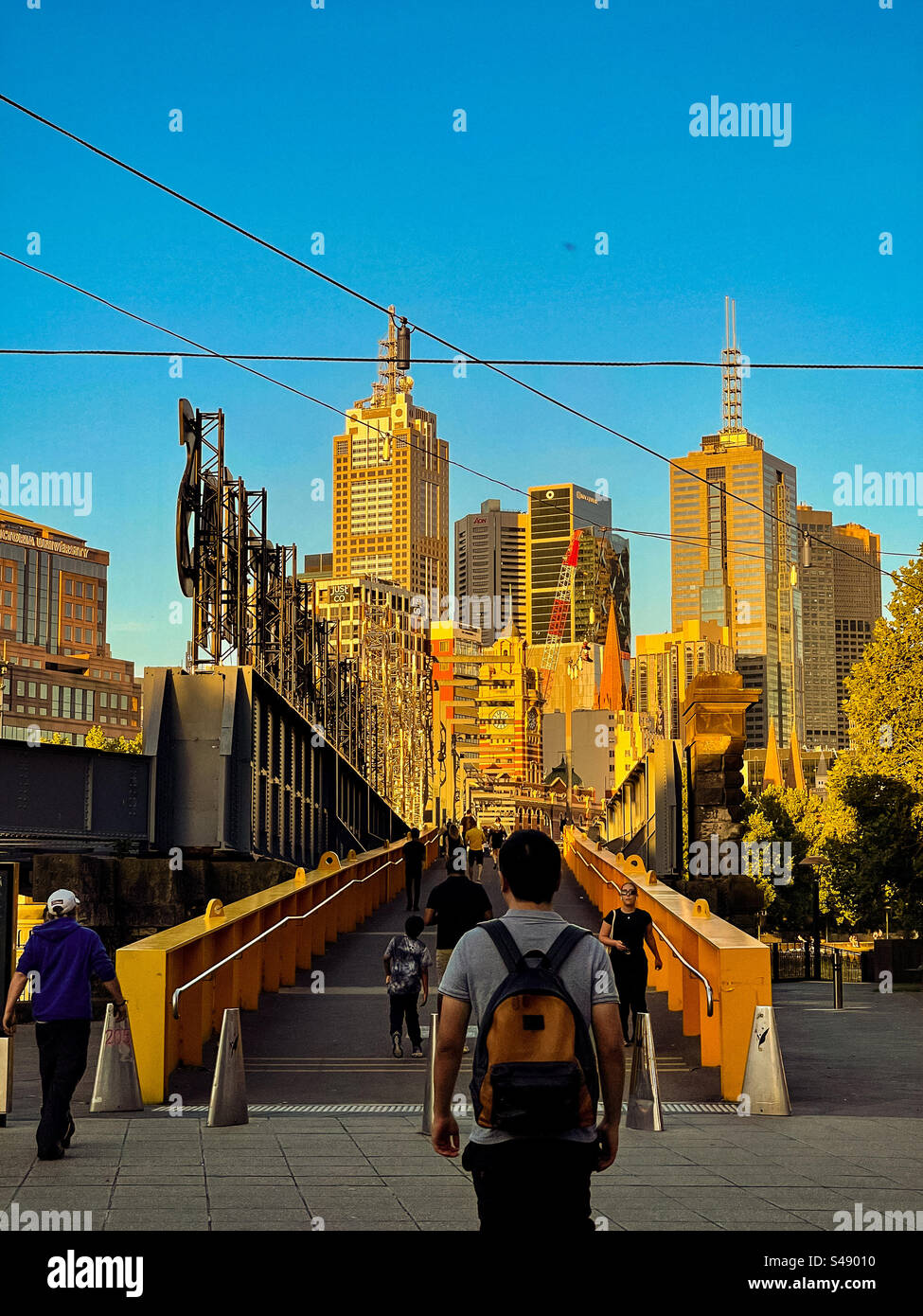 Pedestrians on Sandridge Bridge in Melbourne, Australia with buildings, skyscrapers and city skyline at sunset. - Smartphone Captured Stock Image Pedestrians on Sandridge Bridge in Melbourne, Australia with buildings, skyscrapers and city skyline at sunset. - Smartphone Captured Stock Image