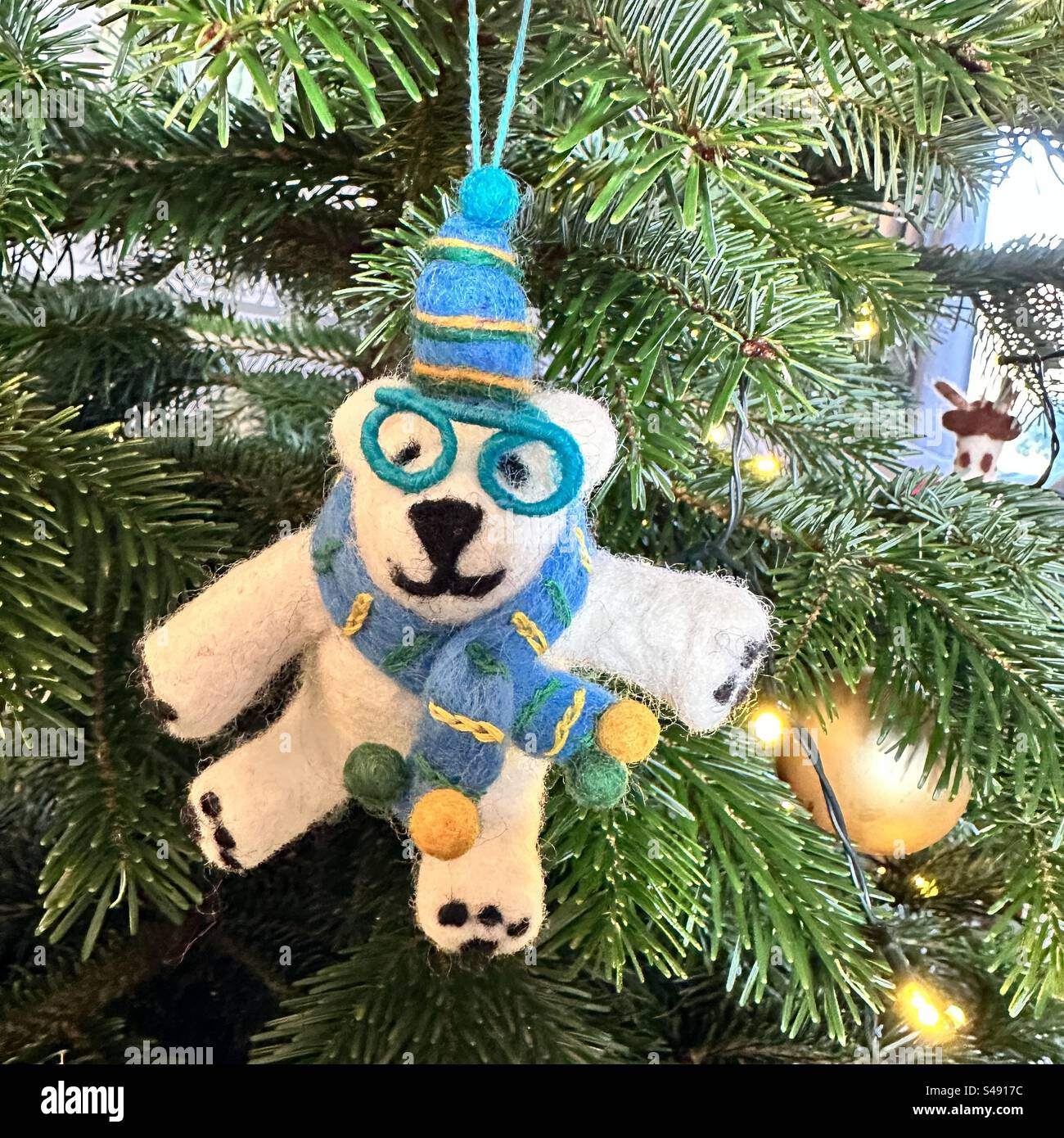 Felted wool polar bear Christmas tree decoration hanging on a Nordmann Fir - Smartphone Captured Stock Image