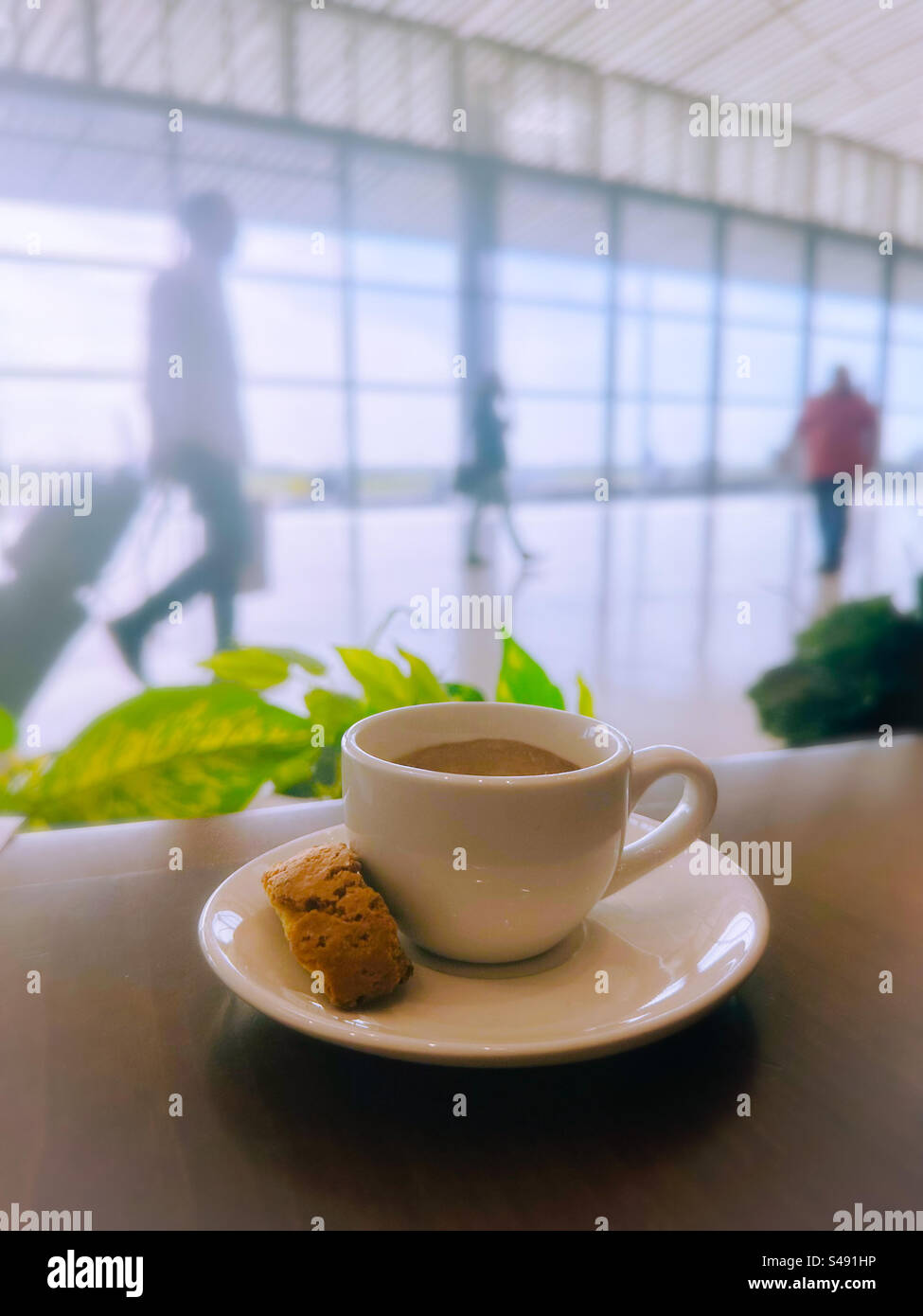 Cup of coffee in the foreground and people moving in the background at Tocumen airport, Panama city - Smartphone Captured Stock Image