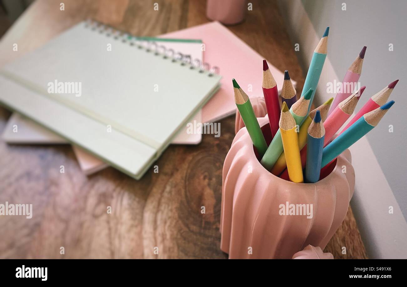 Color pencils and notebooks on a wooden desktop - Smartphone Captured Stock Image