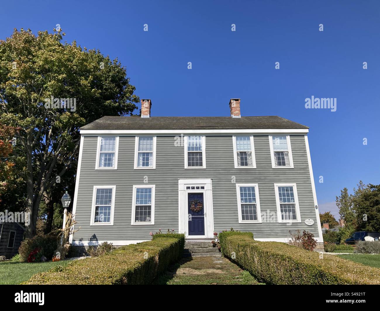 Vintage, wooden house in Clinton, Connecticut, USA.  Bright light shining on house during autumn. - Smartphone Captured Stock Image