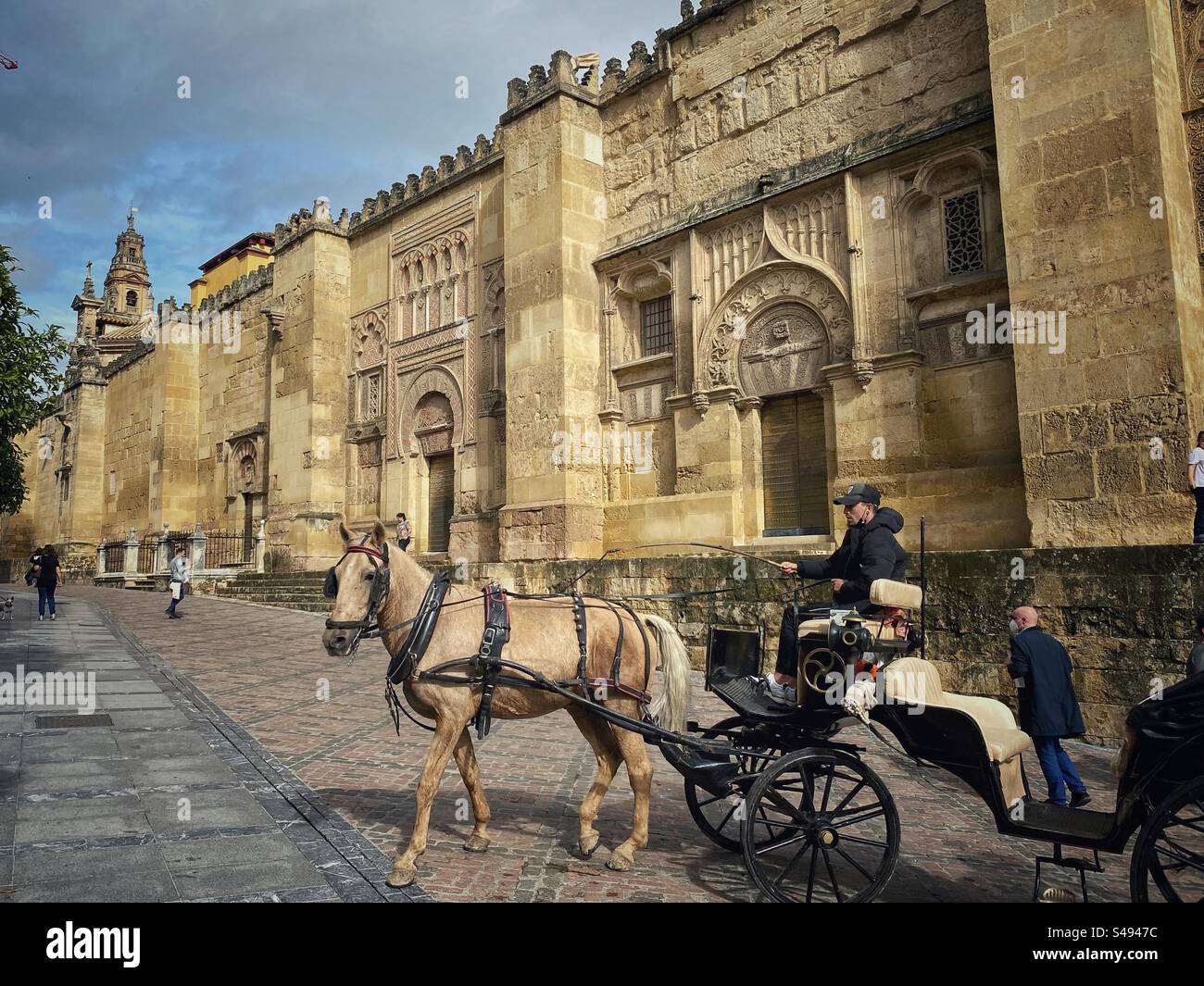 Horse carriage in front of decorated external walls of Mosque-Cathedral in Córdoba, Spain. - Smartphone Captured Stock Image