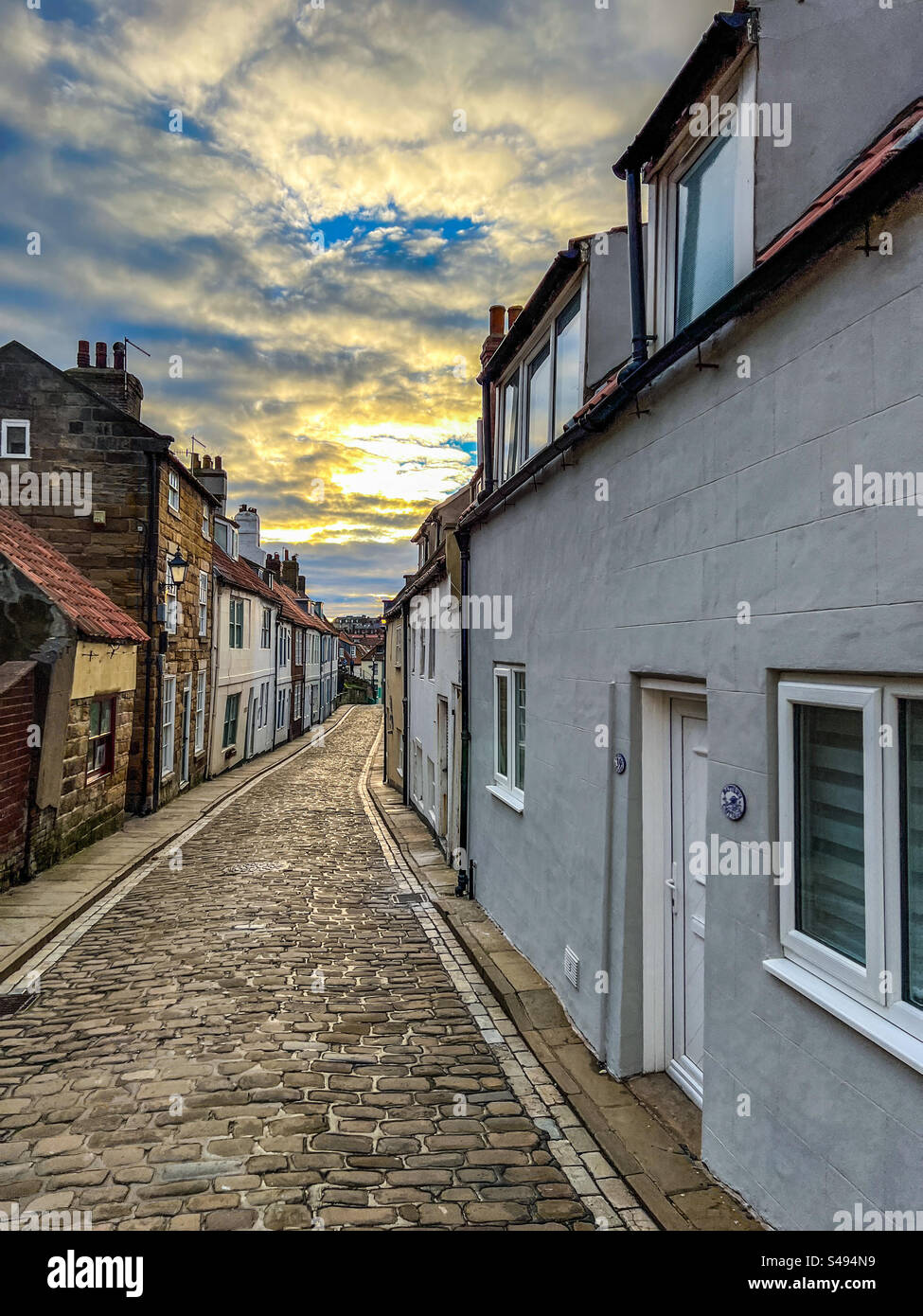 Cobblestone street and quaint houses and cottages on Henrietta Street in Whitby North Yorkshire - Smartphone Captured Stock Image
