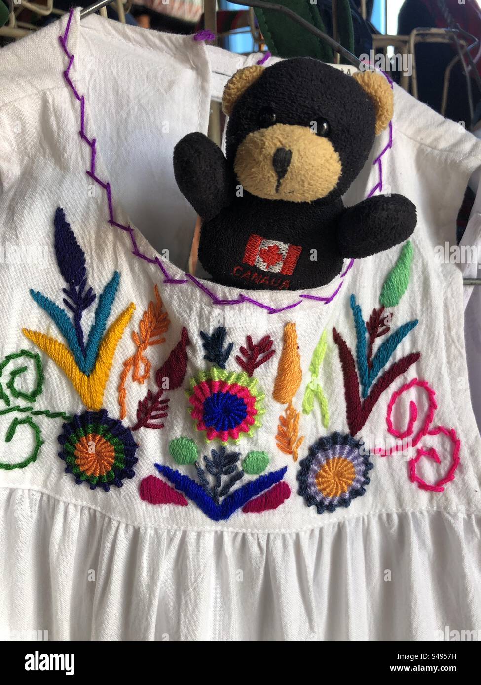 A tiny teddy bear trying on a Guatemalan dress. - Smartphone Captured Stock Image