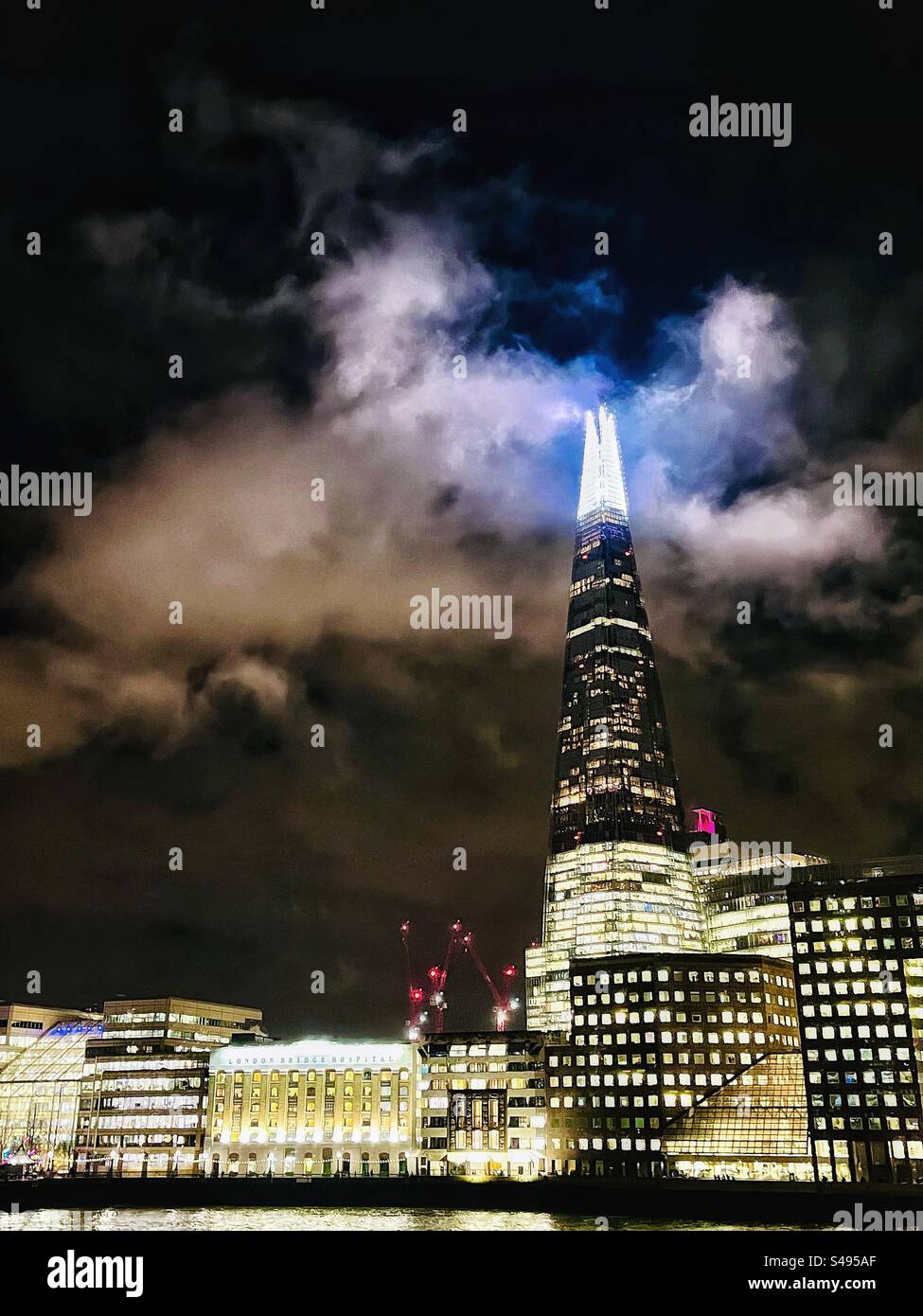 The Shard building in London - photographed from London Bridge seen at night with clouds and lights - Smartphone Captured Stock Image