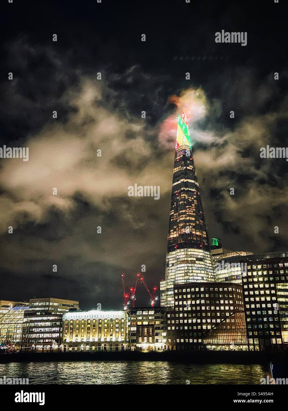 Red, Yellow, Green lights on The Shard, said to be London’s tallest tower on the banks of the River Thames seen on a cloudy night - Smartphone Captured Stock Image