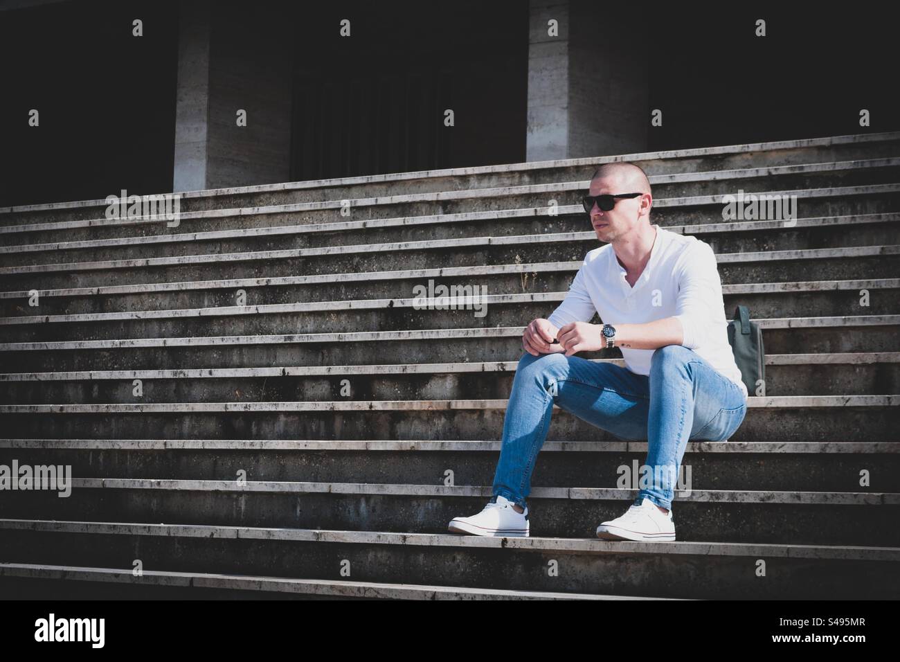 Masculine hungarian man sitting on stairs Stock Photo