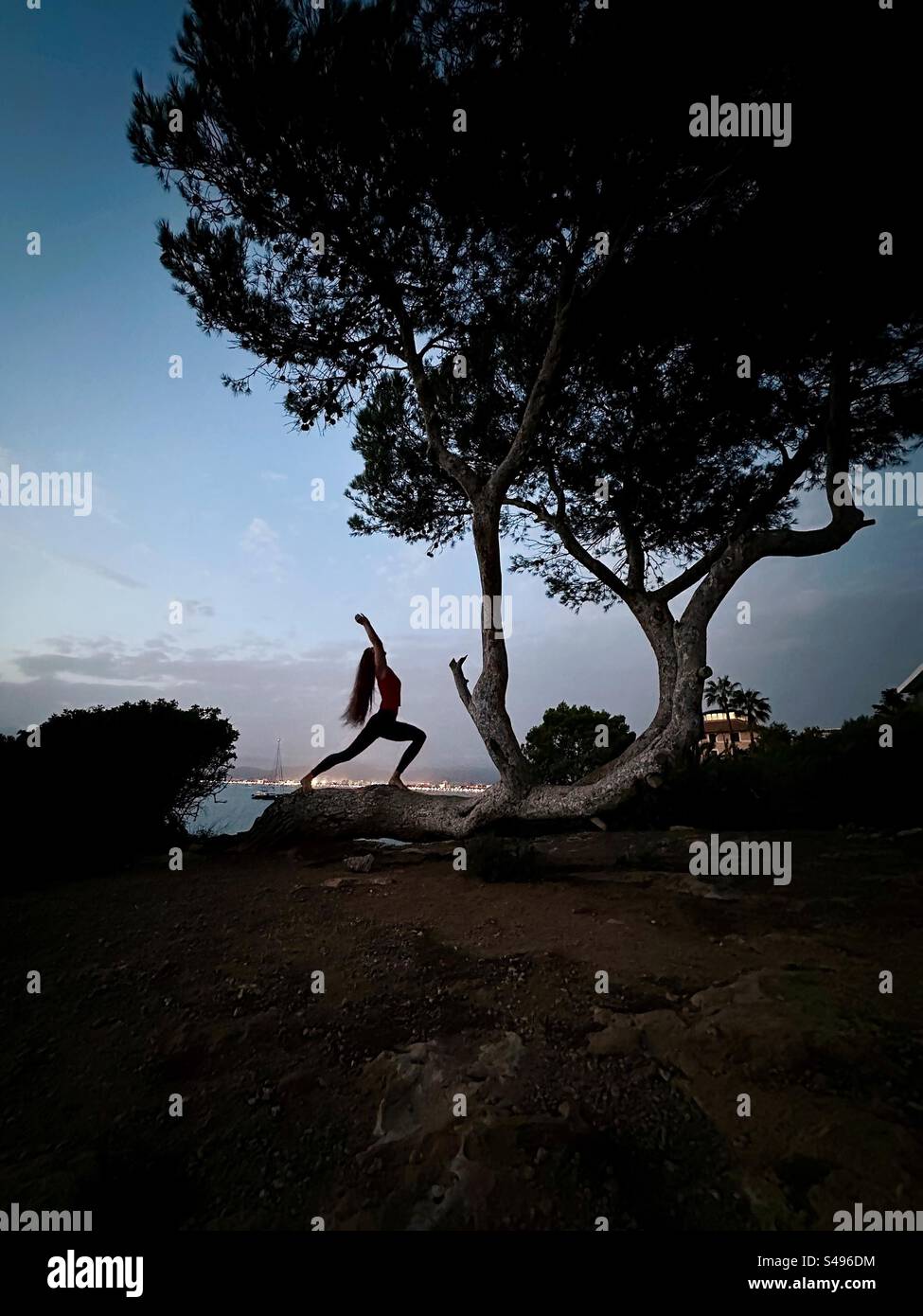 Silhouette of a young woman doing yoga relaxation at sunset - Smartphone Captured Stock Image