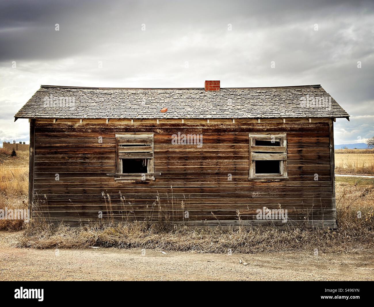 Rundown, wooden building in Mead, Colorado, USA.  Abandoned house with boarded up windows. - Smartphone Captured Stock Image