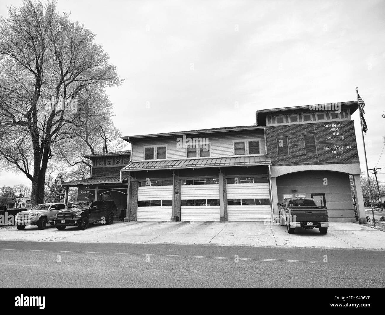 Firehouse station in Mead, Colorado, USA. Trucks parked in front of the building.  Black and white filter. - Smartphone Captured Stock Image