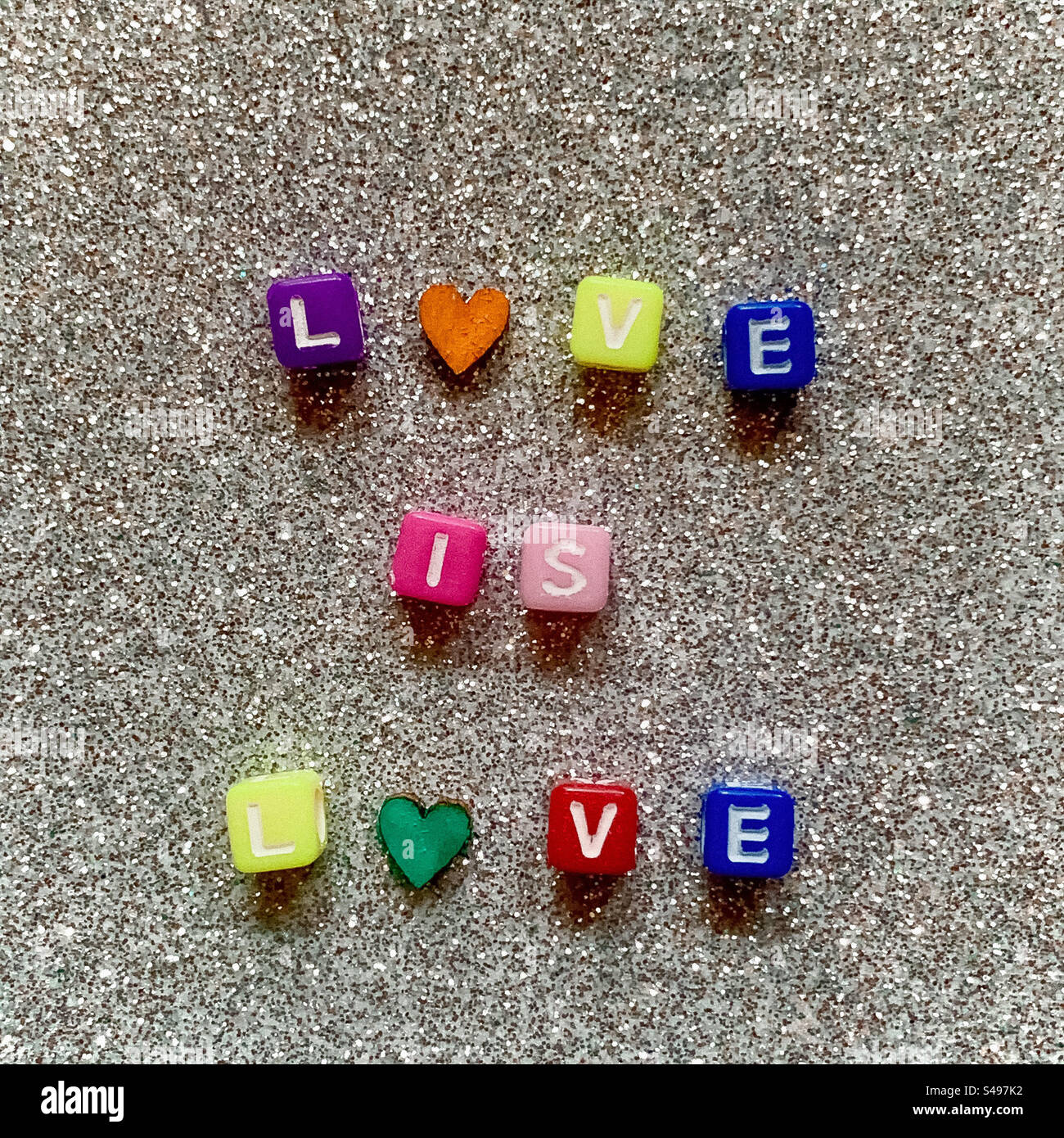Love is Love spelled out with colourful letters on a glittery background Stock Photo