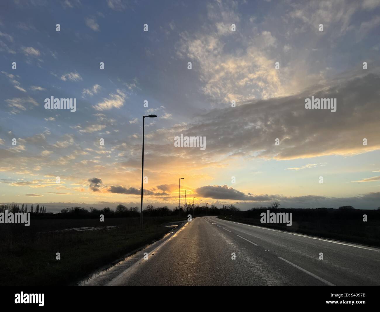 Empty road with golden sunset, Cambridgeshire, England. - Smartphone Captured Stock Image