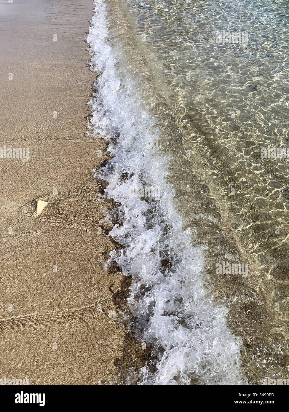 Seashore photo of tide coming in onto the beach and waves lapping on sand at shoreline - Smartphone Captured Stock Image